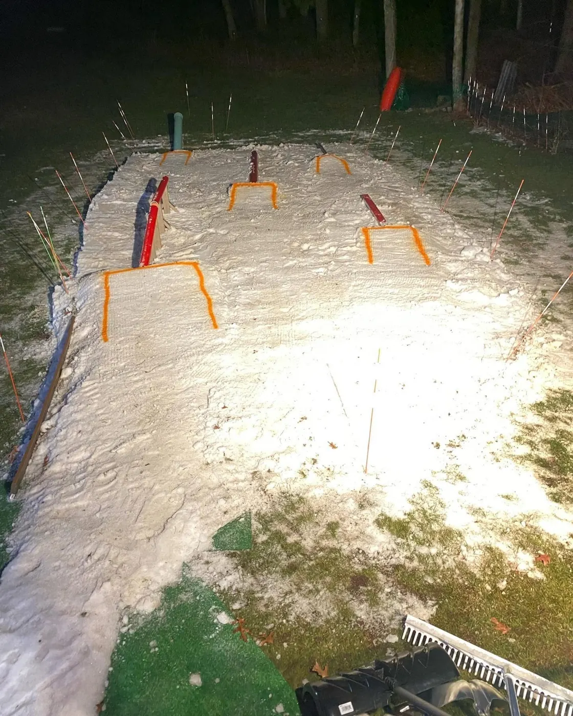 A strip of made snow lit up at night with orange and red features.