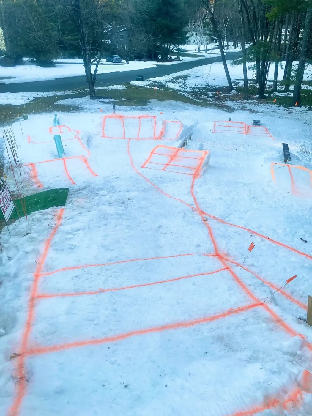A park on snow with features outlined in orange paint.
