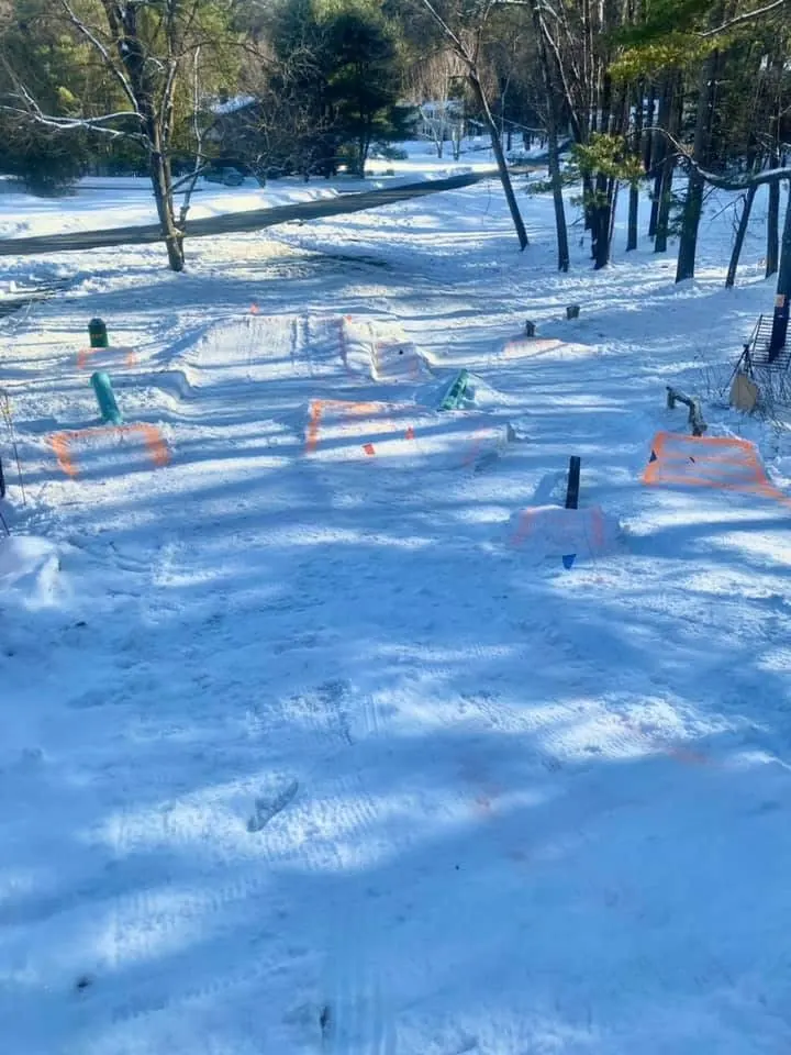 Features on fresh snow marked with orange paint.