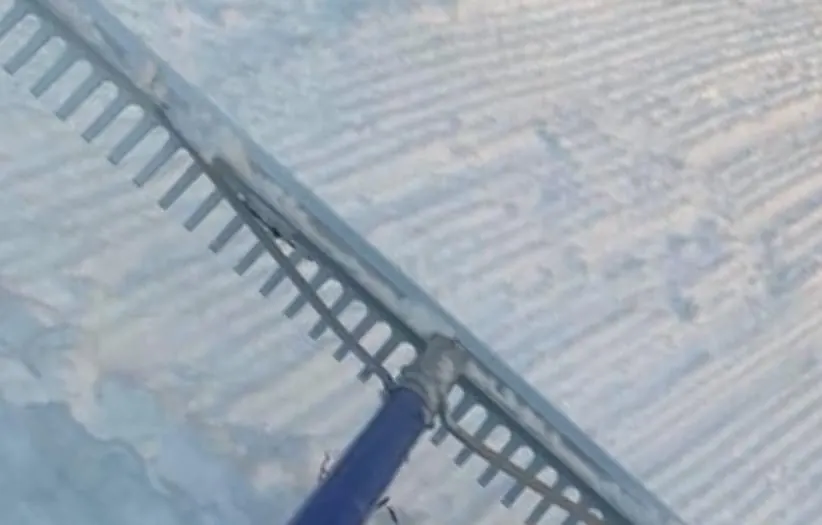 A rake grooming lines into made snow.