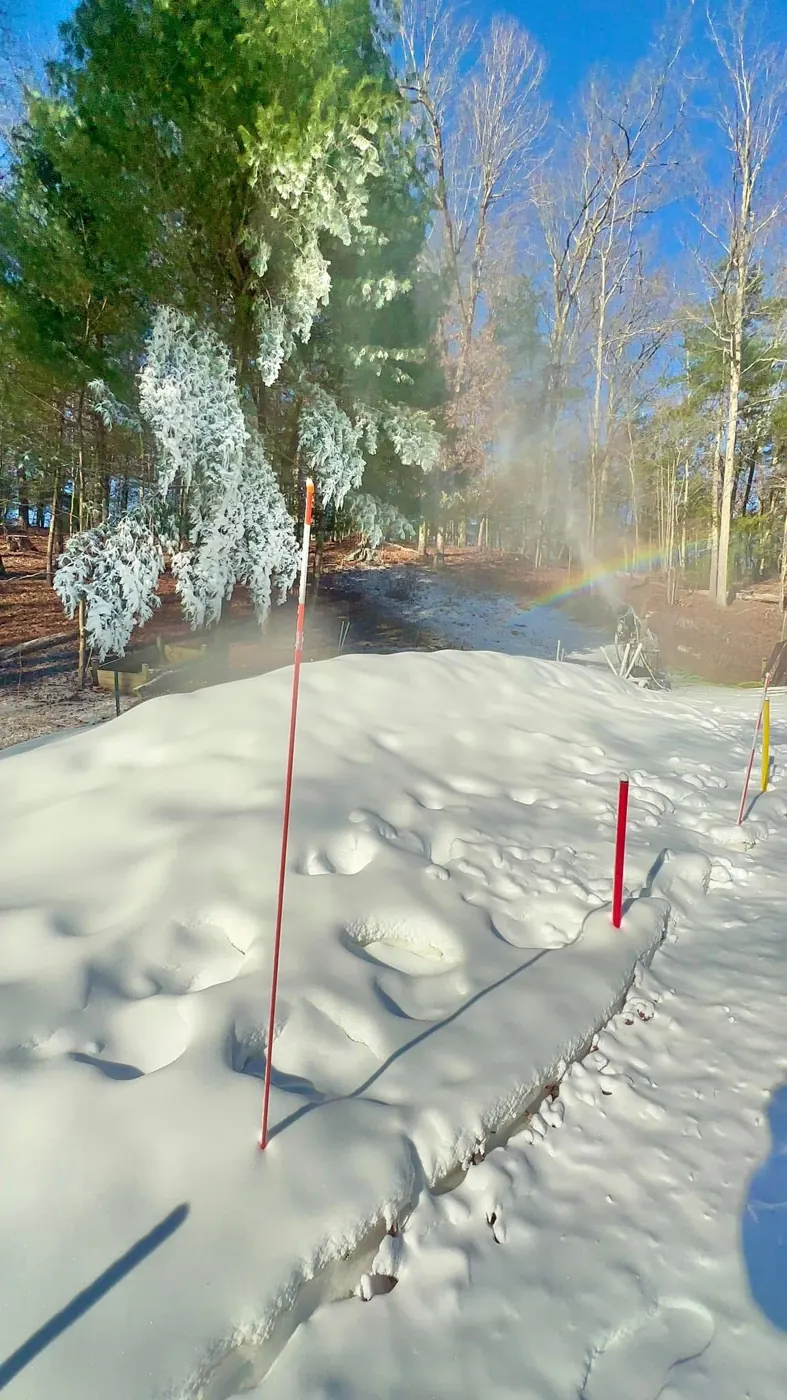 A trail of made snow through the trees.