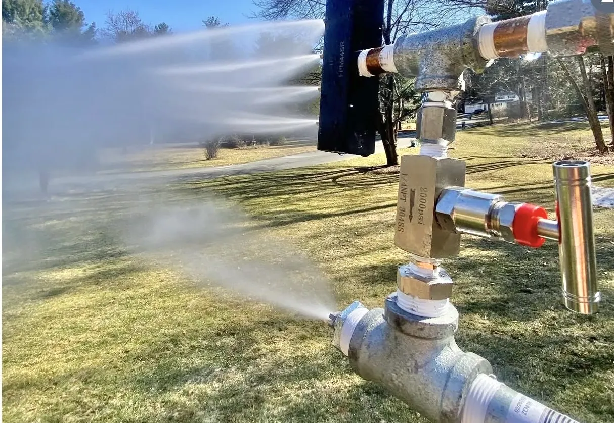 A snowgun running with a nozzle head on a post.